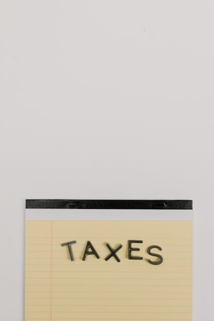 Blocco note con la parola TAXES, tasse e detassazione aumenti contrattuali per l'istruzione, priorità pubblica e crescita economica