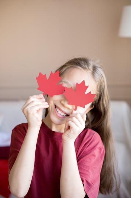 Ragazza sorridente con foglie di acero rosse sugli occhi, simbolo del Canada, che celebra la dignità e l'identità nazionale.