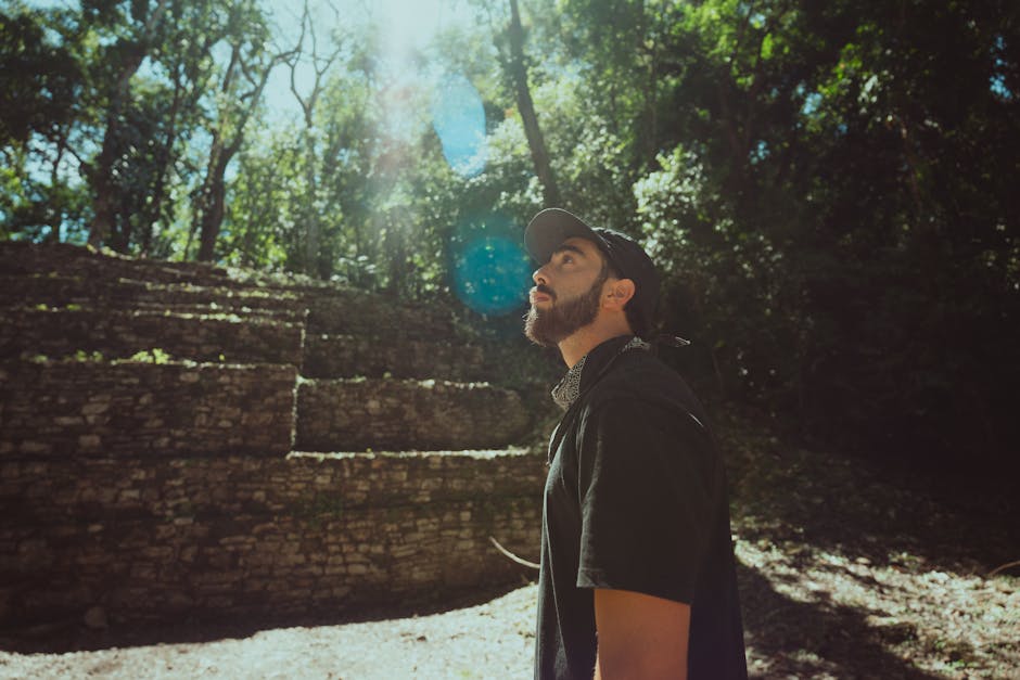 Uomo con barba guarda verso l'alto vicino a rovine antiche, riflessione sulle Crociate e il loro impatto storico e culturale.