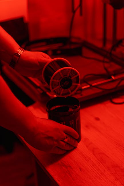 Roll-Stepping Technology: Sviluppo pellicola fotografica in camera oscura con luce rossa, processo innovativo per l'industria.