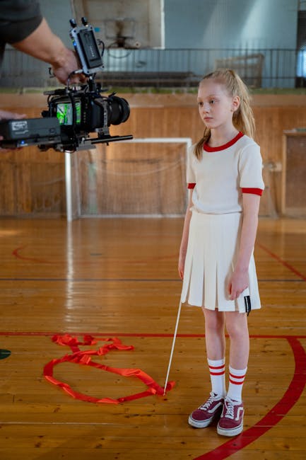 Ragazza sul set di ARCO, film scolastico sull'empatia e il futuro, durante le riprese in una palestra con attrezzatura professionale.