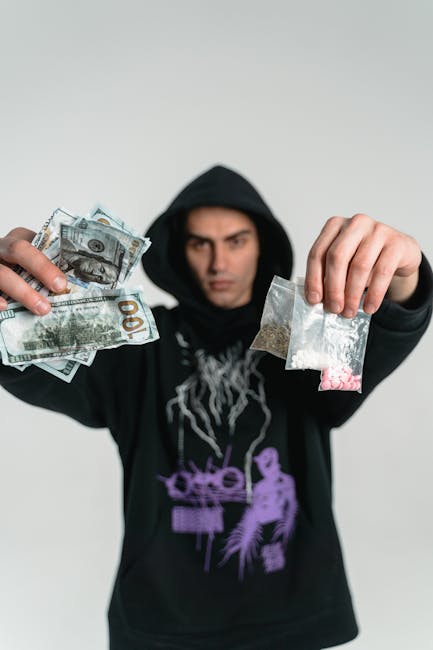 Uomo con felpa nera mostra soldi e bustine sospette, metafora dei rischi finanziari estremi e delle conseguenze inattese.