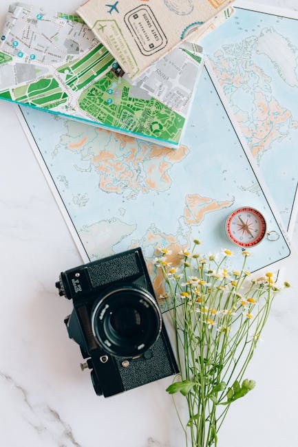 Mappa del mondo, macchina fotografica vintage, bussola e fiori di campo: strumenti per calcolare il tempo di percorrenza ideale.