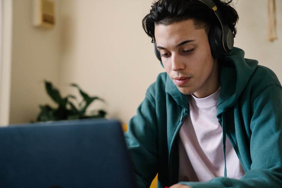 Studente concentrato con cuffie che studia al laptop per esami digitali online strategie efficaci preparazione e successo