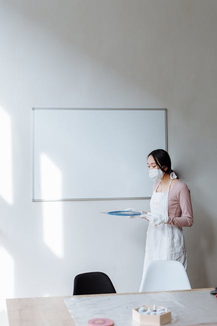 Formazione sulla sicurezza: studentessa con mascherina e guanti in aula, lavagna bianca sullo sfondo. Importanza della prevenzione.