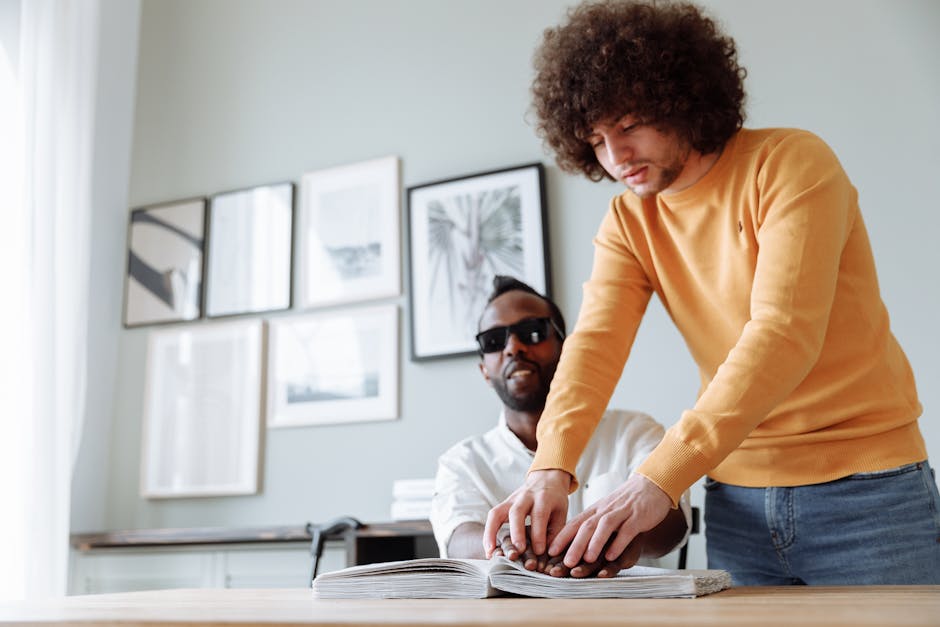 Uomo che spiega BODMAS a persona non vedente tramite libro in braille per apprendimento inclusivo delle regole matematiche