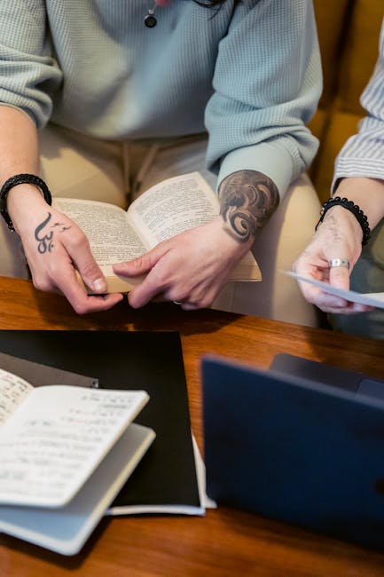 Lettura personalizzata e valutazione adattativa: mani che sfogliano un libro con appunti e laptop, apprendimento su misura.