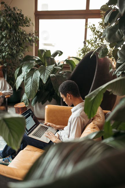 Uomo che lavora al laptop in ufficio didattico verdeggiante, esempio di flessibilità e innovazione con IA negli ambienti di apprendimento.