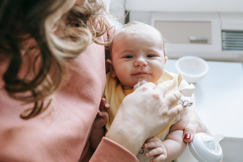 Madre che tiene in braccio neonato con biberon, illustrando l'ansia infantile causata da ipercontrollo genitoriale e le sue conseguenze emotive.