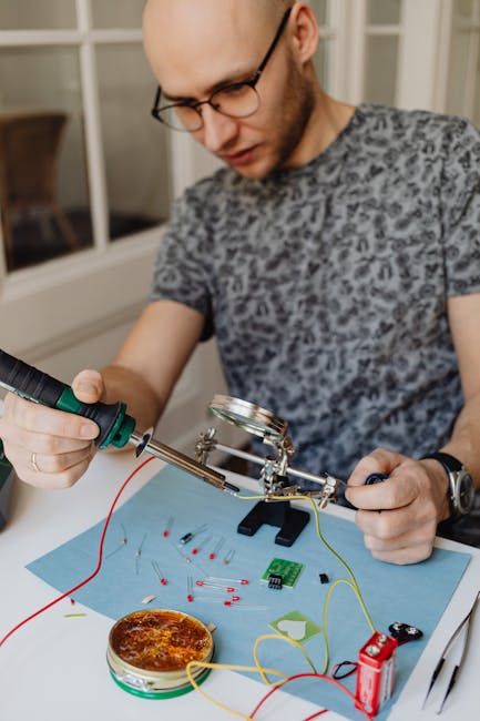 Uomo che salda componenti elettronici su un circuito stampato, applicando principi di circonferenze concentriche per la progettazione.