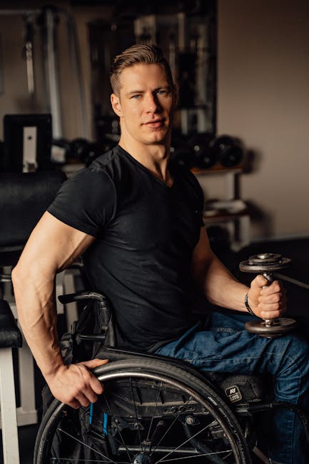 Atleta paralimpico in carrozzina solleva pesi in palestra dimostrando forza e determinazione oltre i limiti fisici durante allenamento intenso.