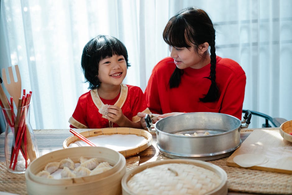 Bambino sorridente e donna preparano ravioli cinesi al vapore, tradizione culinaria asiatica e momenti di condivisione familiare.