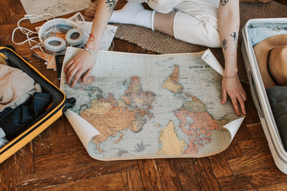 Persona che pianifica un viaggio con mappa del mondo e valigie, ispirazione per scoprire il talento musicale unico attraverso l'esplorazione.