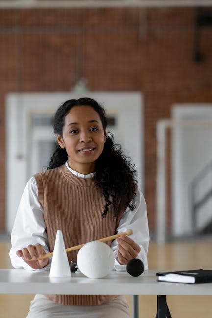 Insegnante spiega geometria con solidi, focus su modernizzazione scuole e didattica innovativa per un futuro sostenibile.