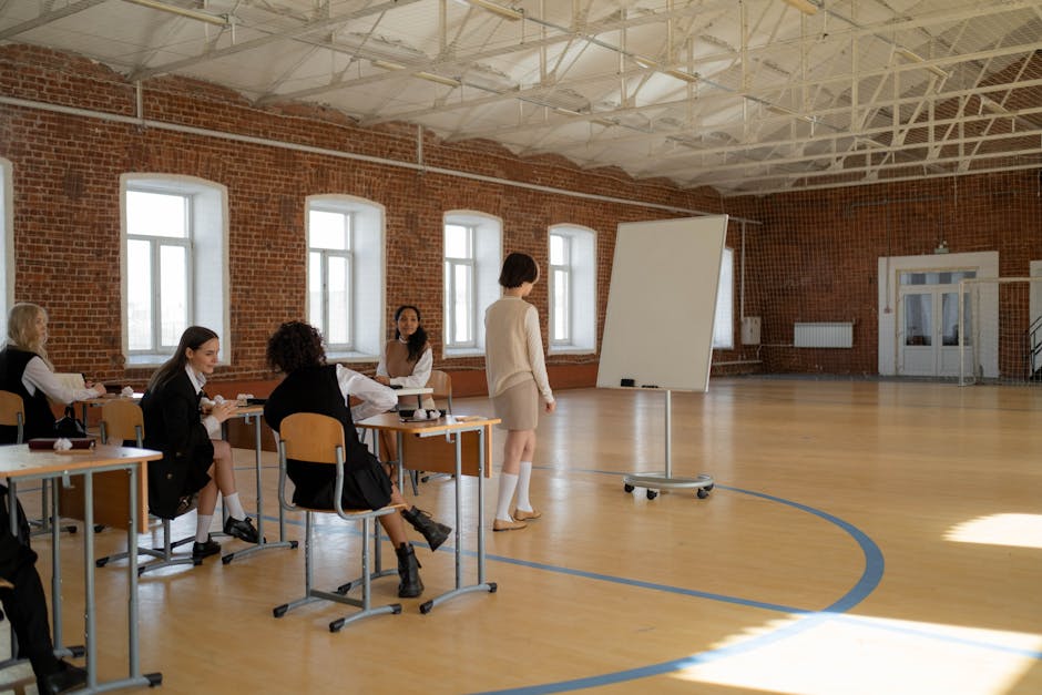 Studenti in palestra durante lezione di scienze motorie con giochi strutturati, focus sull'apprendimento attivo e coinvolgimento nella scuola secondaria.