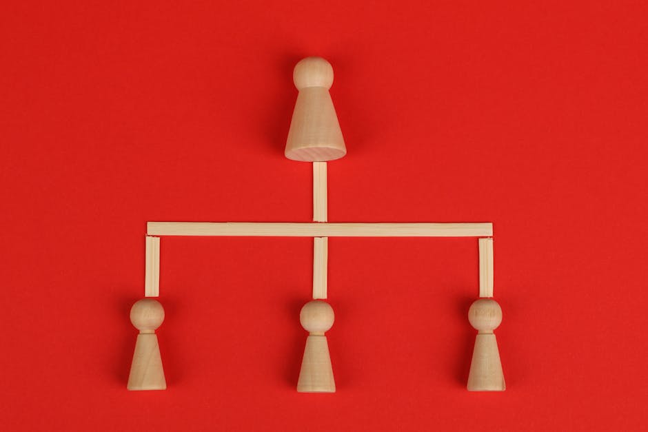 Schema concettuale con pedine di legno su sfondo rosso che illustra la rete di relazioni tra elementi distintivi