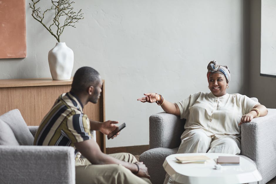 Due persone conversano sedute in poltrona, esprimendo abilità relazionali e superando difficoltà sociali per la crescita personale.