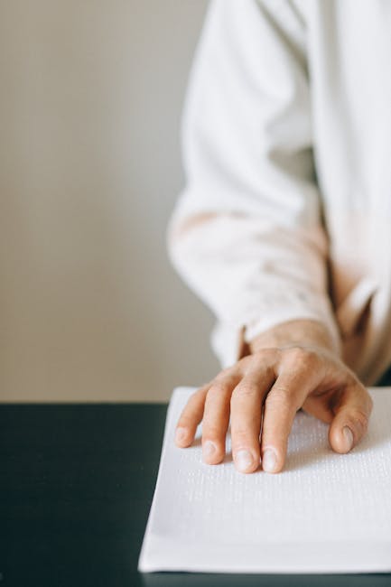 Persona che legge un testo in braille, esempio di tecnologia inclusiva per la didattica e l'accessibilità all'istruzione.