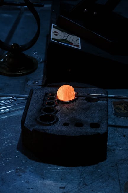 Sfera incandescente su supporto metallico, metafora di valutazione e standardizzazione per esami equivalenti.