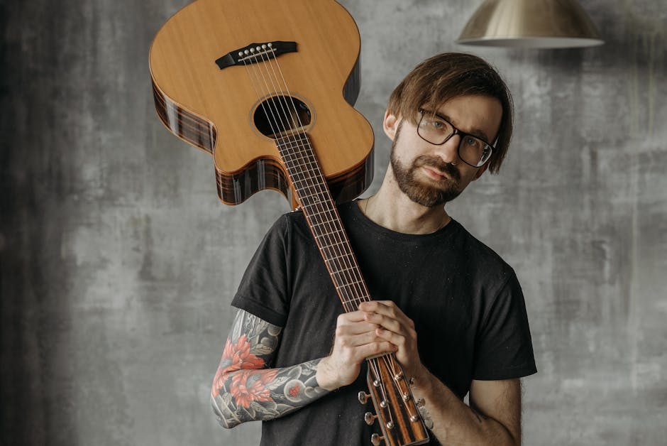 Musicista con chitarra acustica, espressione creativa e talento musicale unico, sviluppo consapevole del potenziale artistico, tatuaggio floreale sul braccio.