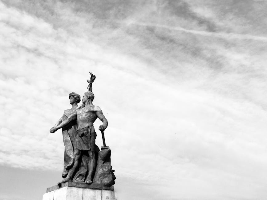 Scultura in bianco e nero di figure eroiche, simbolo di forza e destino nell'Eneide, con cielo nuvoloso sullo sfondo.