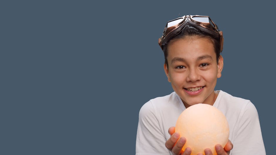 Ragazzo sorridente con occhiali da aviatore che tiene una sfera luminosa, simbolo di divertimento e scoperta nel gioco delle differenze.