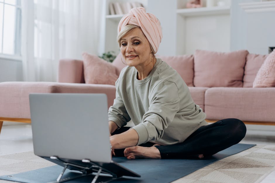 Donna matura che partecipa a lezione online di yoga da casa, apprendimento digitale e benessere con nuove metodologie didattiche