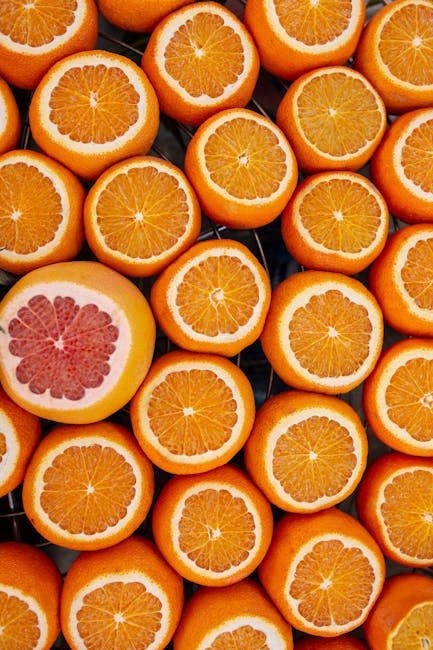 Arance e pompelmo tagliati a metà, perfetti per illustrare la conversione oncia-grammi in cucina e ricette.