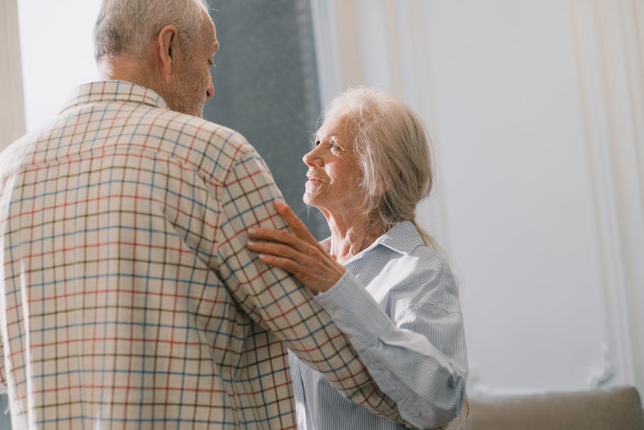 Coppia anziana si guarda con affetto, simbolo del tocco magico dell'amore familiare e della memoria condivisa in età avanzata.