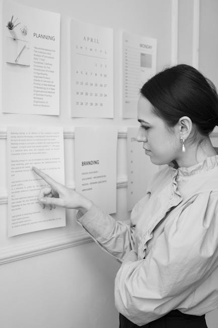 Donna esamina documenti affissi al muro, pianificazione scolastica e revisione per settembre e ottobre.