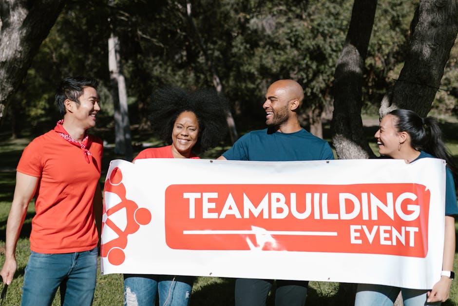 Gruppo eterogeneo sorridente con striscione Team Building Event, diversità e inclusione aziendale per successo organizzativo