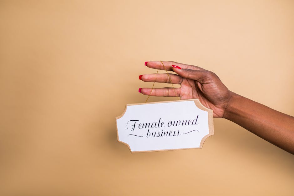 Mano che tiene cartello Female owned business: assicurazione per aziende femminili e protezione del business