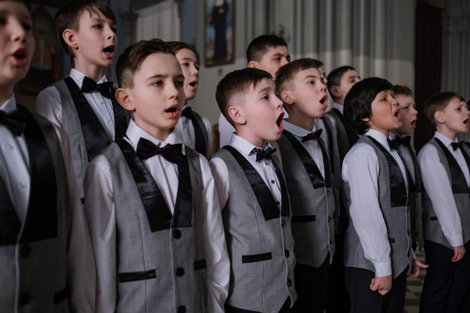 Coro scolastico di voci bianche in concerto. Giovani cantori in divisa esprimono passione e impegno nell'educazione musicale.