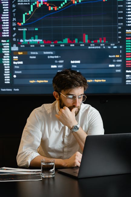 Trader analizza grafici finanziari al computer per trading CFD, strategie di investimento intelligente e gestione del rischio economico