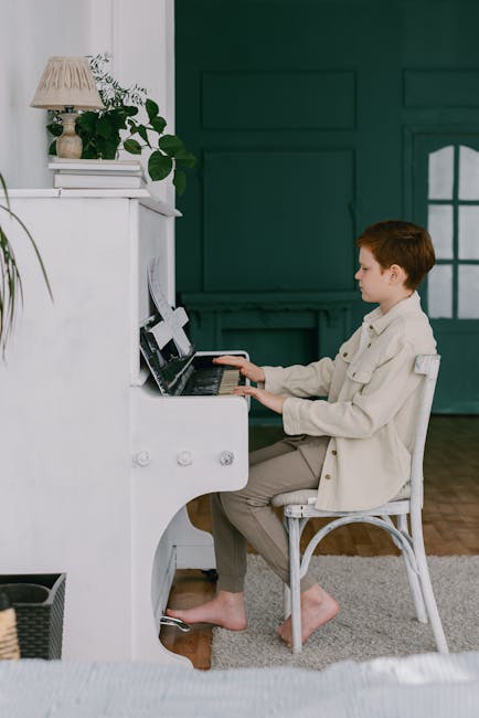 Ragazzo che suona il pianoforte bianco: importanza dell'educazione musicale per lo sviluppo cognitivo e creativo dei giovani
