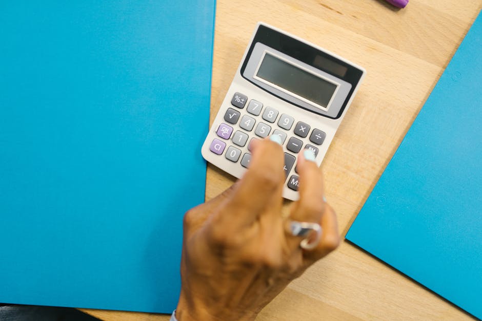 Calcolatrice e mano che digita, difficoltà esami matematica finanziaria, calcoli complessi, preparazione e studio, concetti finanziari
