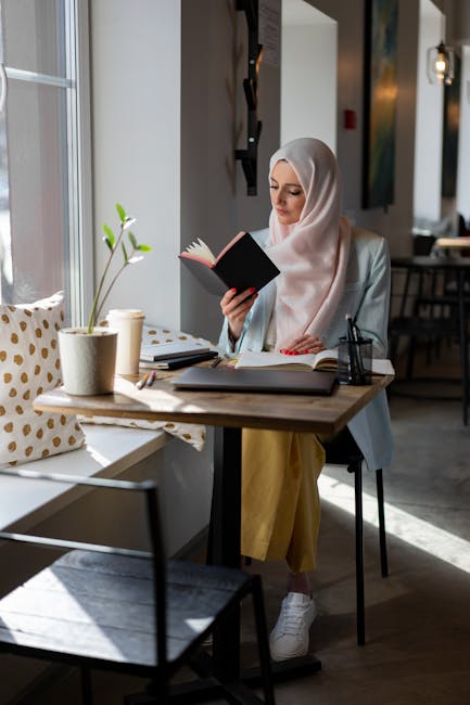 Donna con hijab studia online vicino alla finestra, apprendimento efficace e metodologie didattiche innovative