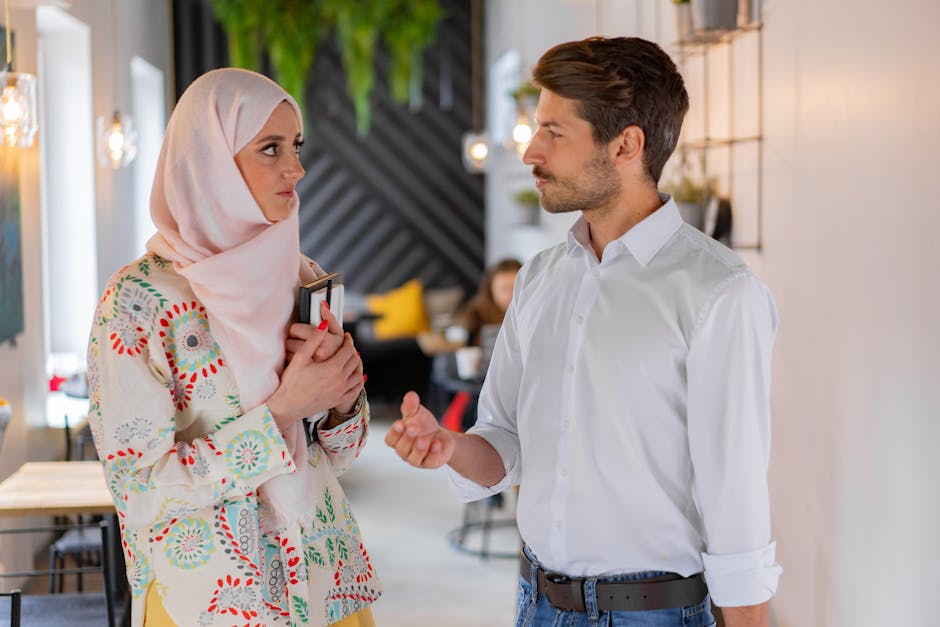 Studentessa con hijab e studente discutono, rappresentazione del Dipartimento di Scienze Politiche e Sociali e dialogo interculturale.