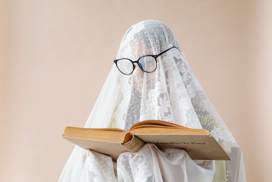 Figura velata con occhiali legge libro antico, metafora della riscoperta dei classici come Virgilio e Leonardo da Vinci