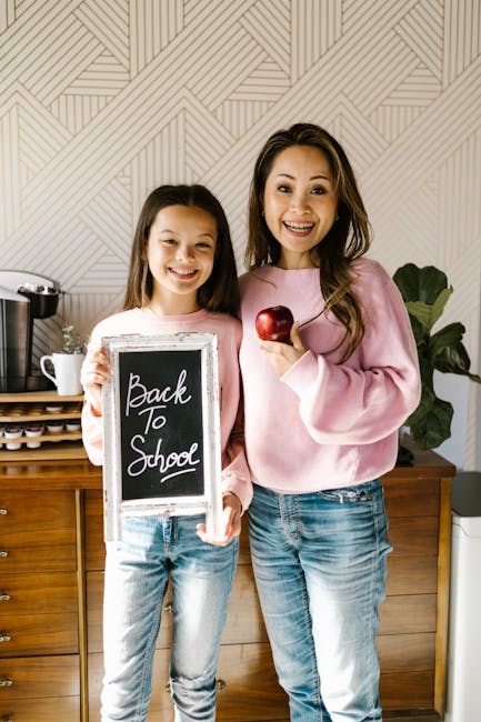 Madre e figlia sorridenti con lavagnetta Ritorno a Scuola e mela, esempio di coinvolgimento genitori nell'educazione scolastica