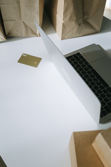 Calcolo del valore attuale: laptop, carta di credito e pacchi per analisi finanziaria e decisioni di investimento strategiche.