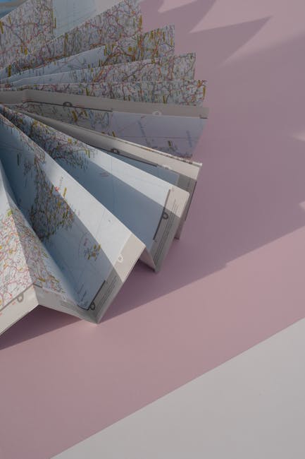 Pianificazione finanziaria e assicurazione sulla vita: mappa piegata a ventaglio su sfondo rosa, simbolo di protezione e futuro sicuro.