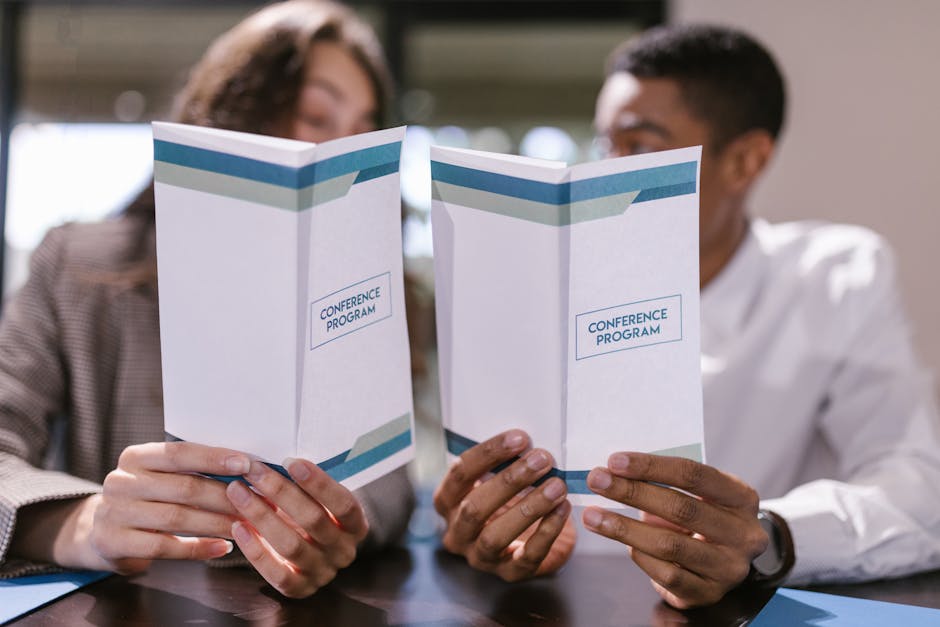 Persone leggono programma conferenza: esempio sottotitoli efficaci per catturare l'attenzione e migliorare la lettura di un testo.