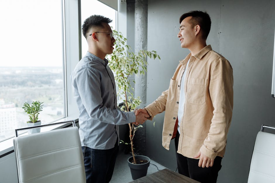 Due uomini d'affari asiatici si stringono la mano in segno di accordo, simbolo di soluzioni innovative e successo aziendale