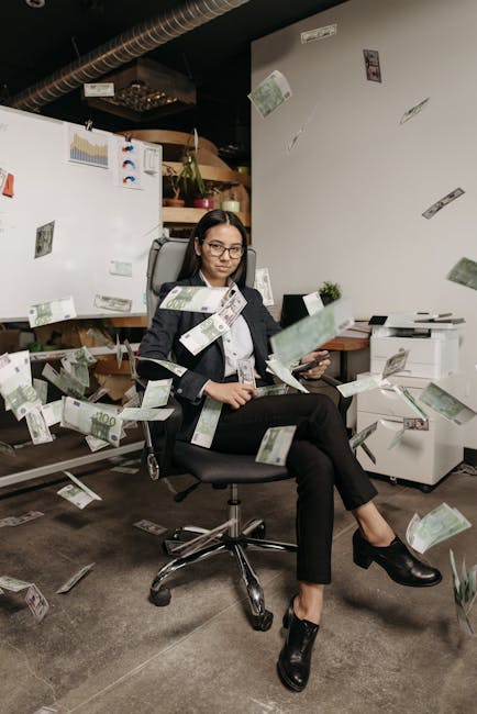 Donna in ufficio seduta su una sedia con banconote che cadono, simbolo di successo nell'arbitraggio finanziario e investimenti