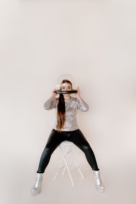 Donna con casco spaziale e abbigliamento futuristico seduta su sgabello, esempio di design angoloidi innovativo e creativo
