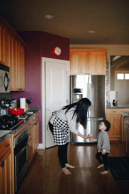Madre offre frutto al figlio in cucina: equilibrio tra alimentazione e schermi nella crescita dei bambini italiani