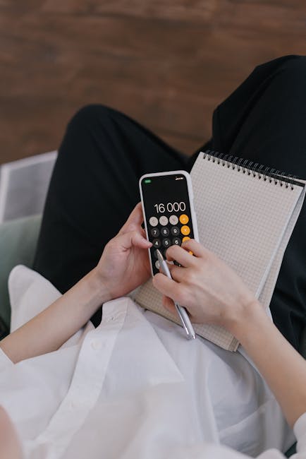 Calcolatrice su smartphone e blocco note per analisi finanziaria e politica monetaria delle banche centrali