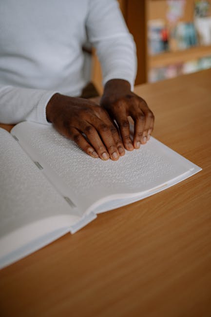 Persona che legge un libro in braille, simbolo di inclusione e accessibilità nell'istruzione per persone con disabilità visiva.