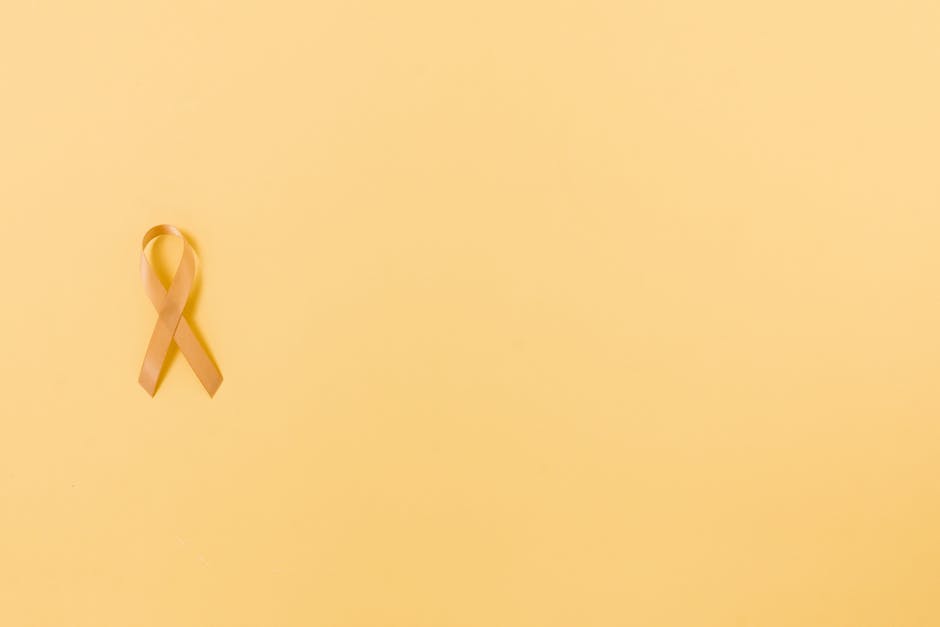 Nastro color oro su sfondo giallo chiaro, simbolo di consapevolezza e supporto, rilevanza per le scienze della vita e la matematica applicata.